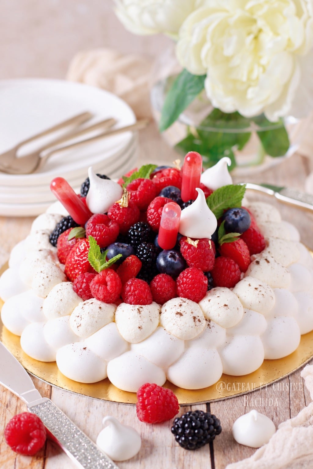 recette de pavlova décoré avec des fruits rouges , de la chantilly légère et un confit de framboise