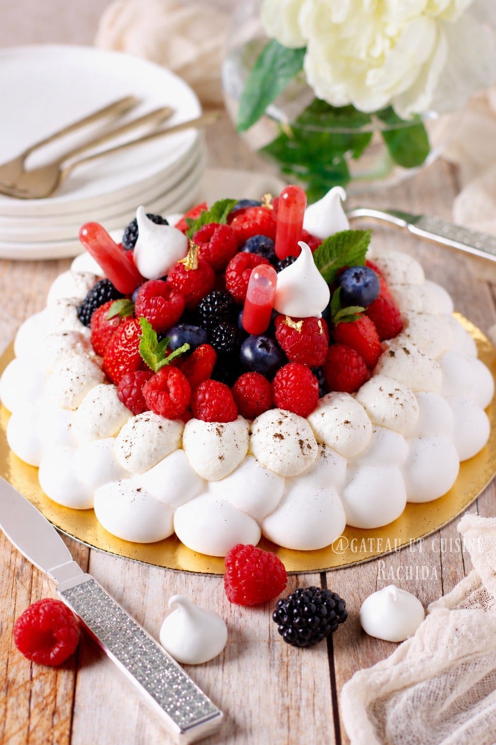Pavlova en couronne avec des boules superposées garnie de fruits rouges frais et de chantilly légère et aérienne